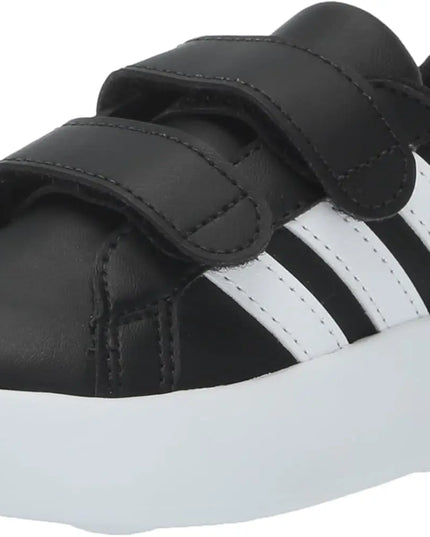 Black and white sneaker with velcro straps on a white background