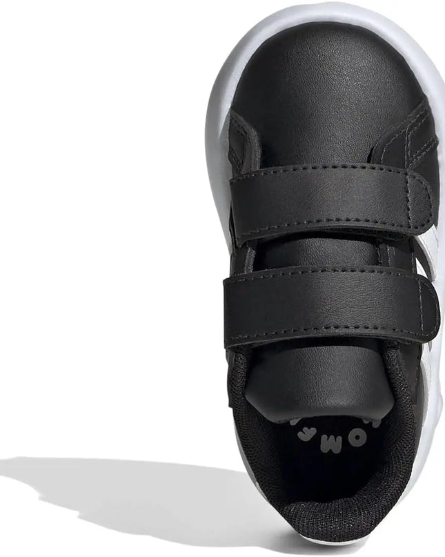 Black children's shoe with velcro straps on a white background