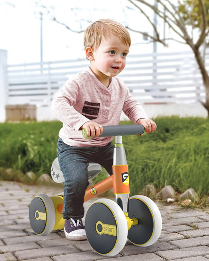 Child riding a balance bike on a paved path with grass and trees in the background
