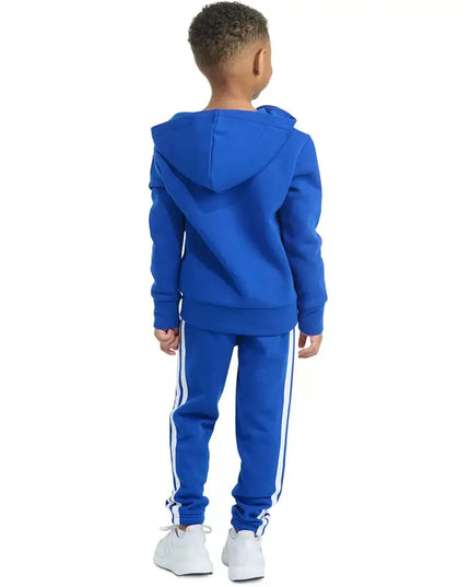 Child wearing a blue tracksuit with white stripes on a white background