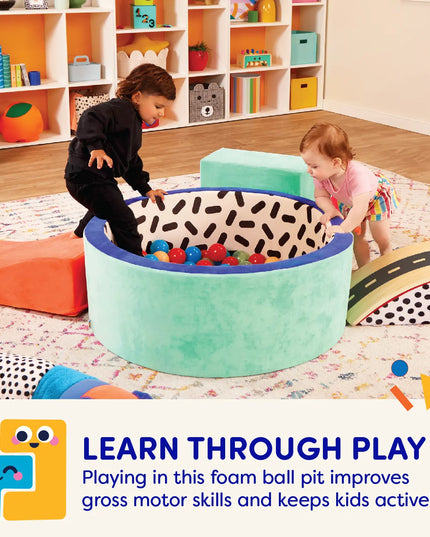 Children playing with a foam ball pit in a colorful playroom.