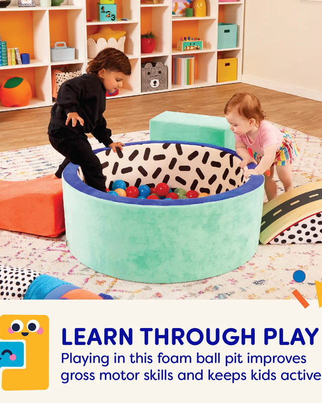 Children playing with a foam ball pit in a colorful playroom.