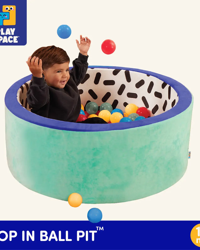 Child playing in a colorful ball pit with 'Play Space' branding.