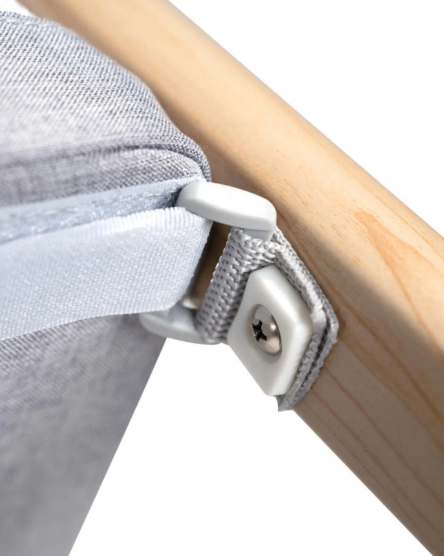 Close-up of a gray fabric draped over a wooden rod with a white clip securing it.