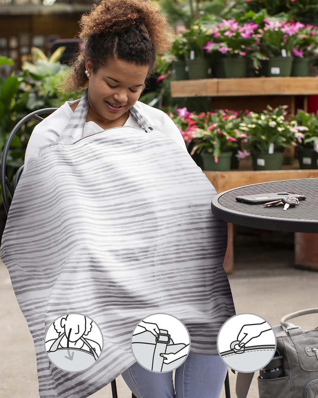 Person using a striped poncho in a garden setting with plants and a table.