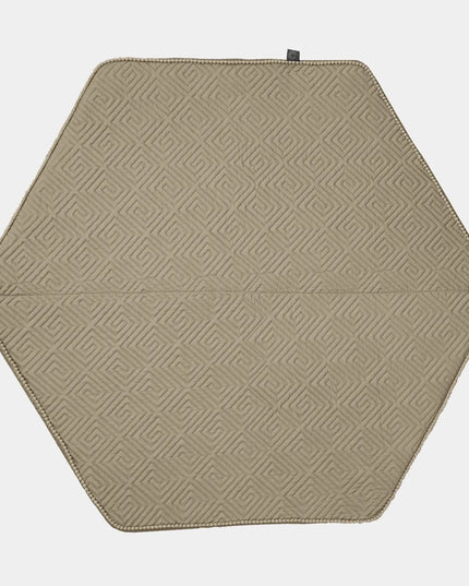 Hexagonal beige placemat with geometric pattern on a white background
