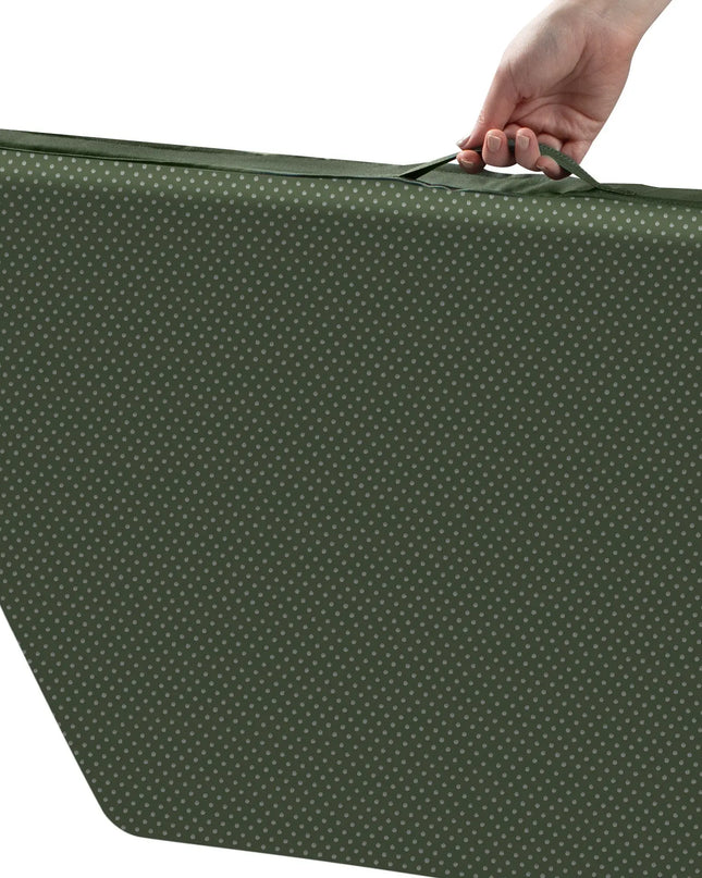 Green polka dot suitcase with a hand holding onto it on a white background