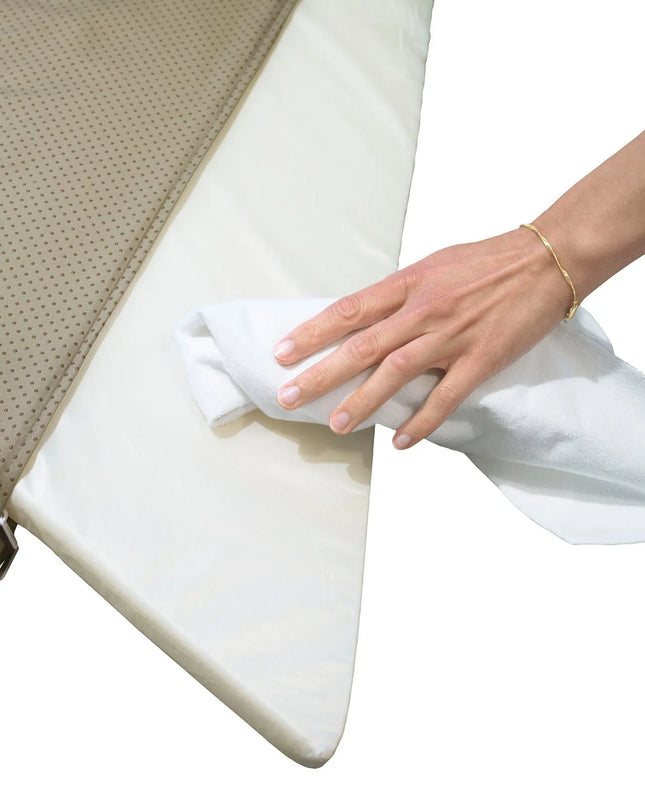 Person cleaning a mattress with a white cloth
