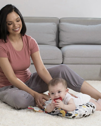 Woman sitting on the floor with a baby in a living room setting