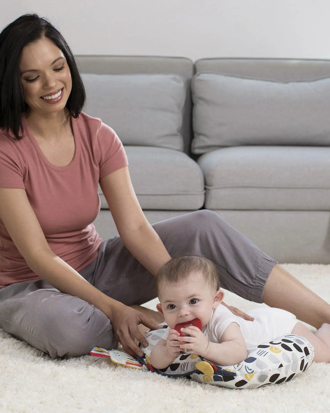 Woman sitting on the floor with a baby in a living room setting