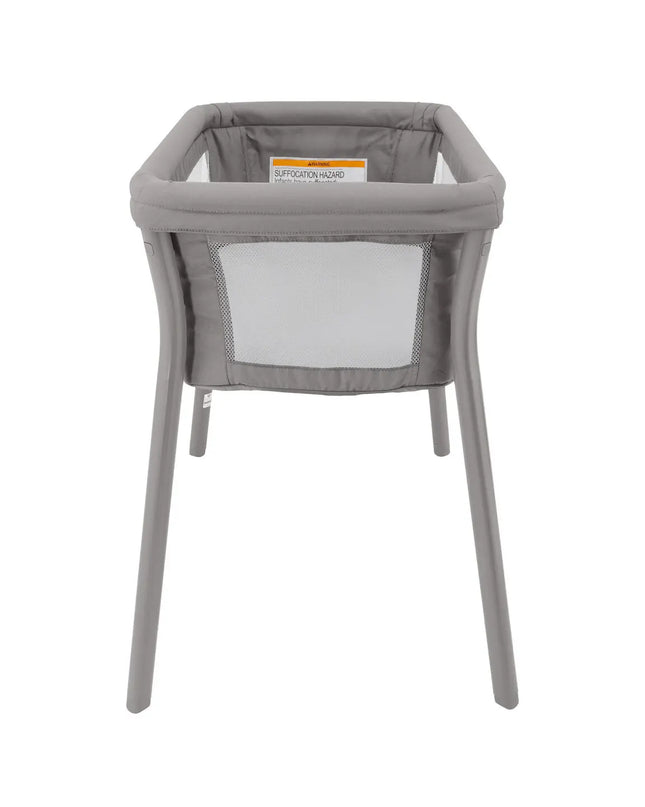 Gray baby bassinet with mesh side on a white background
