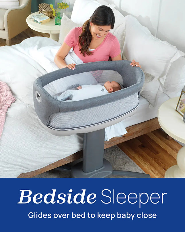 Woman with a baby in a bedside sleeper on a bed in a home setting
