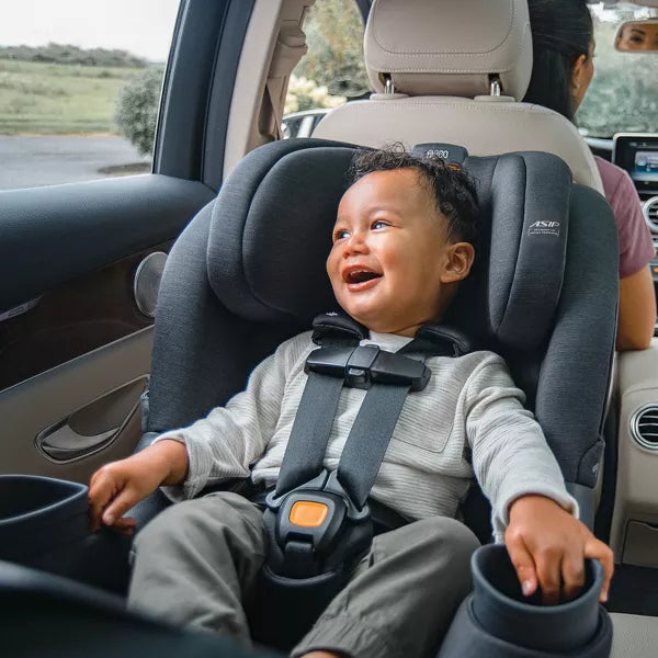 Child in a car seat inside a vehicle with a blurred background