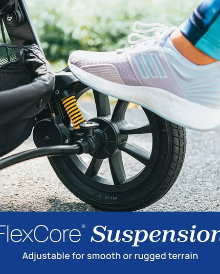 Close-up of a stroller wheel with FlexCore Suspension system, showing a foot pressing down on it.