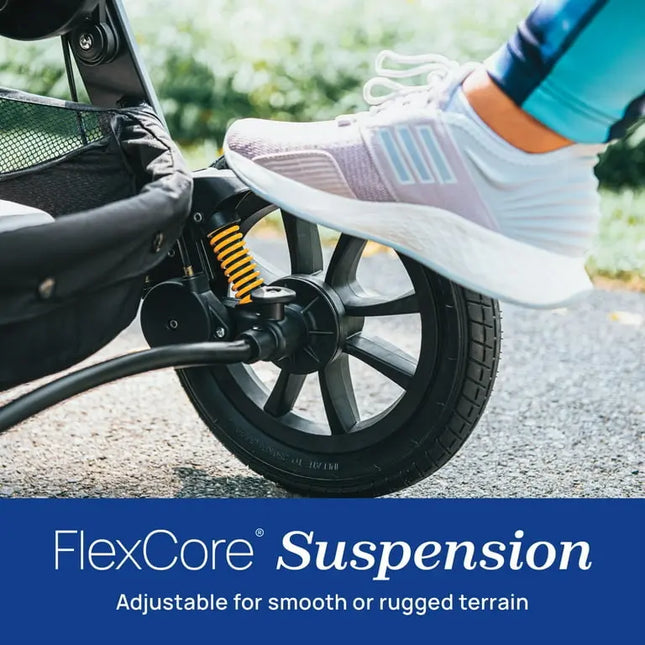 Close-up of a stroller wheel with FlexCore Suspension system, showing a foot pressing down on it.