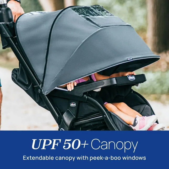 Child in a stroller with a UPF 50+ canopy, outdoor setting