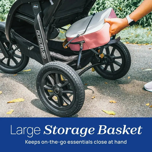 Person placing a pink bag into a stroller with a large storage basket feature highlighted.