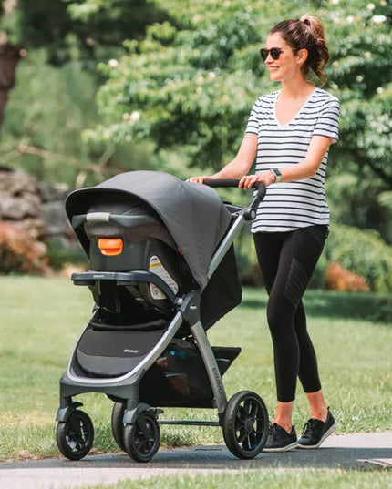 Woman pushing a stroller in a park
