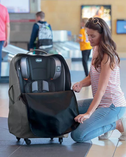 Woman with a travel car seat in an airport setting