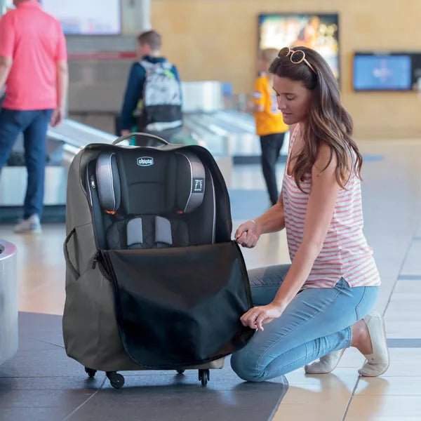 Woman with a travel car seat in an airport setting