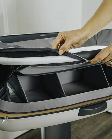 Person opening a gray and black suitcase with a white background