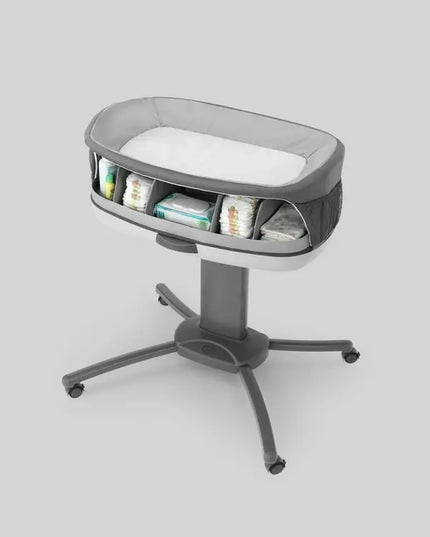 Gray baby bassinet with wheels on a light gray background