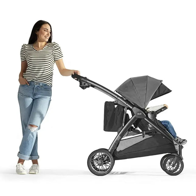 Woman pushing a black stroller on a white background