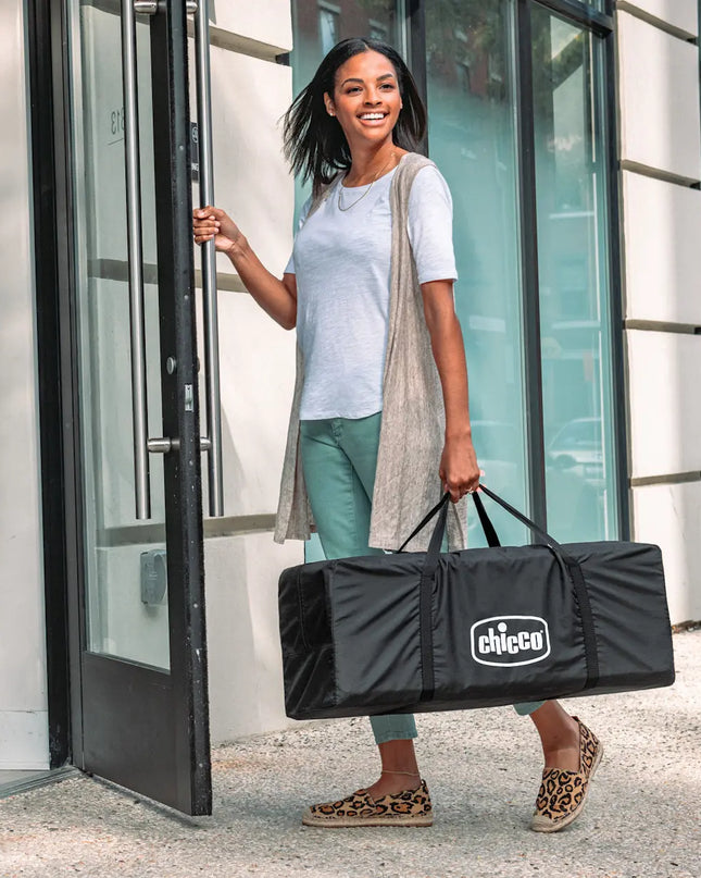 Woman holding a Chicco bag as she exits a building