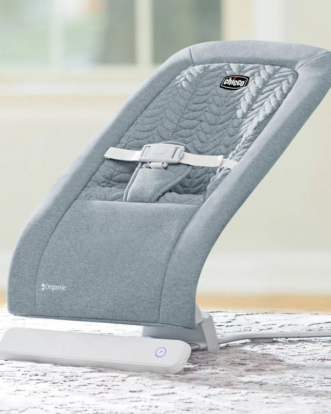 Gray baby bouncer with white base on a light wooden floor