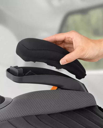 Hand adjusting a car seat cover on a car seat with a blurred background