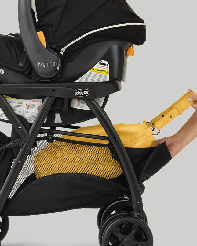 Black stroller with a yellow rain cover and a hand holding the rain cover.