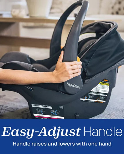 Baby car seat with an easy-adjust handle being held, set against a blurred indoor background.