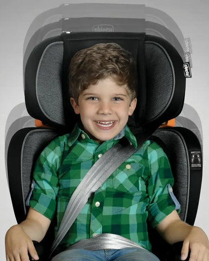 Child in a green checkered shirt sitting in a car seat with a gray background