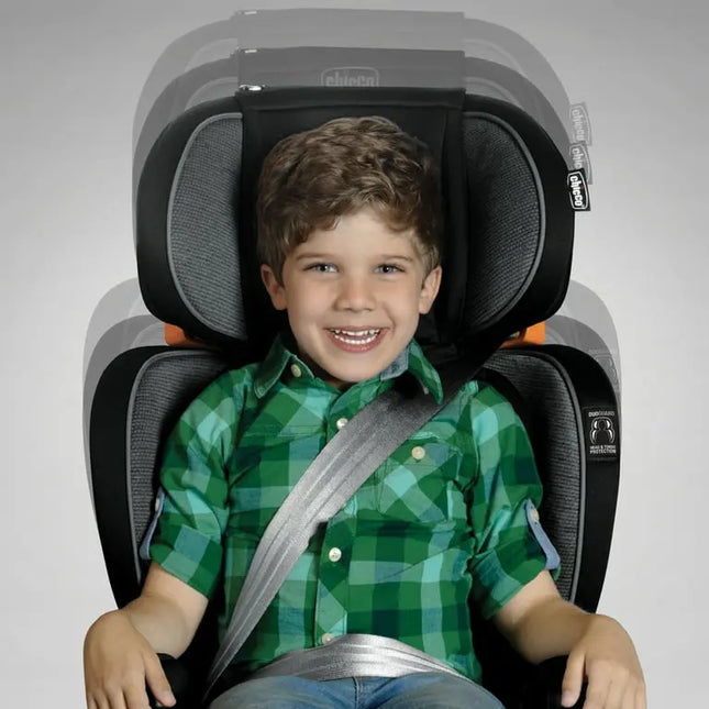 Child in a green checkered shirt sitting in a car seat with a gray background