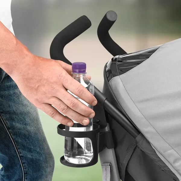 Hand holding a water bottle in a stroller cup holder with a blurred background