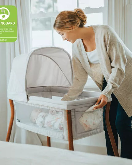 Woman setting up a baby bassinet in a room with natural light