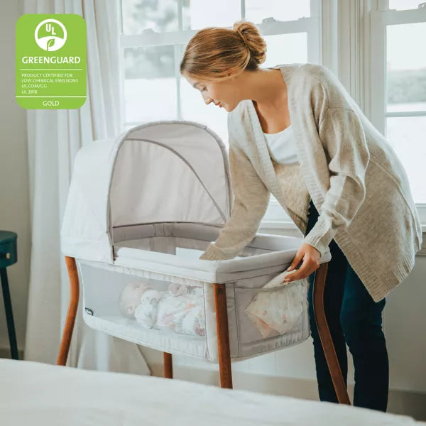Woman setting up a baby bassinet in a room with natural light