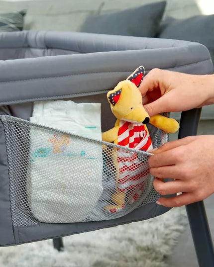 Person placing a plush toy into a mesh pocket of a baby bouncer.