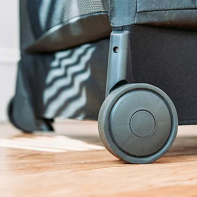 Close-up of a suitcase wheel on a wooden floor