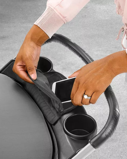 Person placing a cup into a car cup holder with a gray background