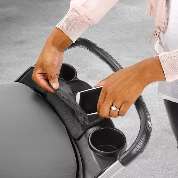 Person placing a cup into a car cup holder with a gray background