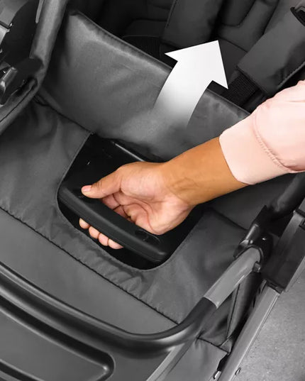 Hand reaching into a stroller tray to place an item inside