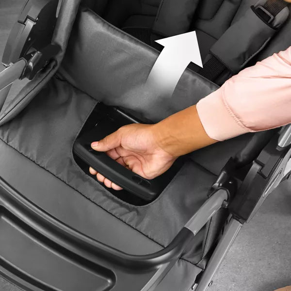 Hand reaching into a stroller tray to place an item inside