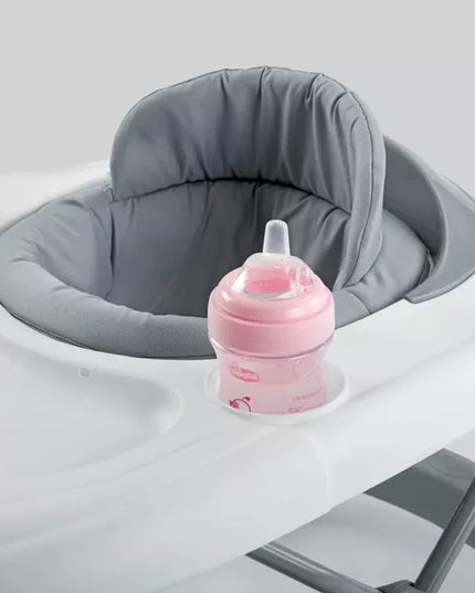 Pink baby bottle on a gray cushioned tray against a white background