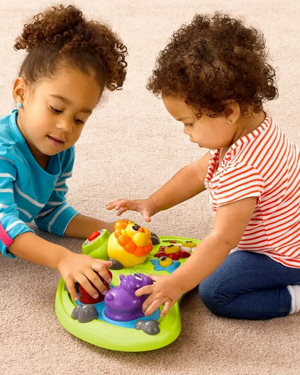 Two children playing with a colorful toy on a carpeted floor.