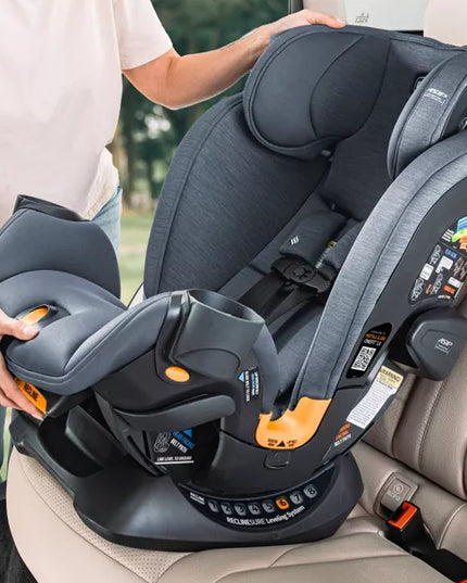 Person installing a gray car seat in a vehicle