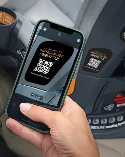 Hand holding a phone with a QR code displayed in front of a car seat