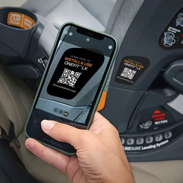 Hand holding a phone with a QR code displayed in front of a car seat
