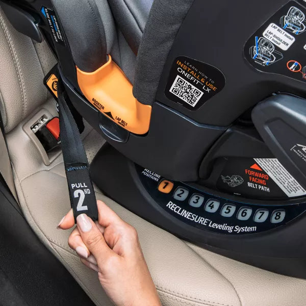 Child car seat with a hand adjusting the strap, showing the 'ReclineSure' leveling system.