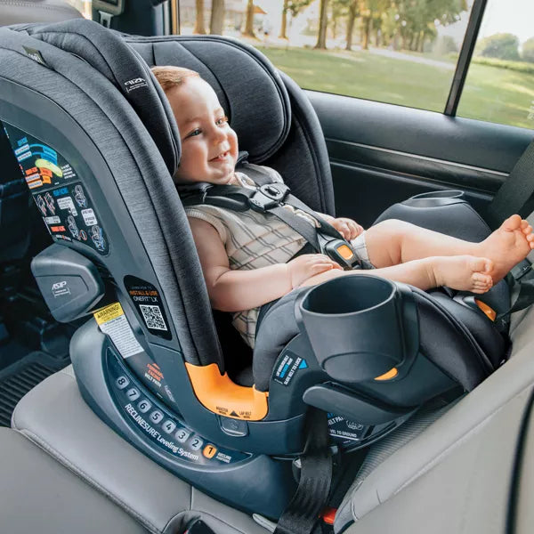 Child in a car seat inside a vehicle with a scenic background